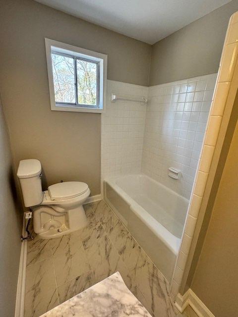 full bath featuring toilet, baseboards, and marble finish floor