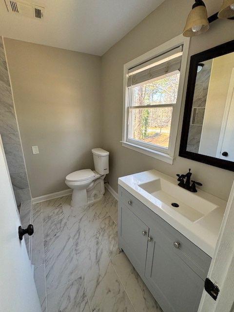 bathroom featuring vanity, visible vents, baseboards, toilet, and marble finish floor