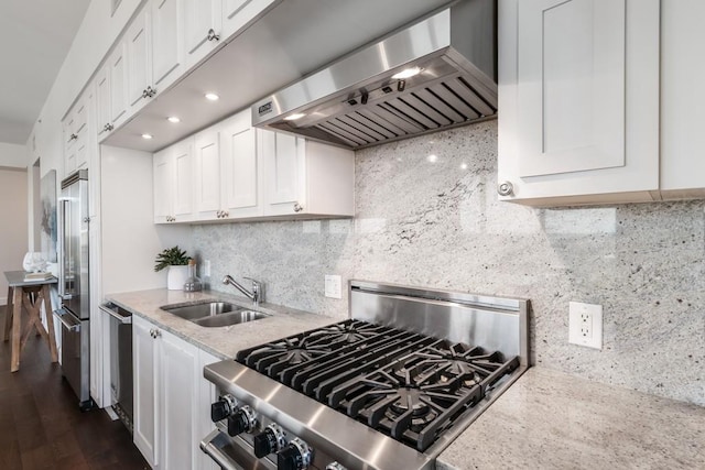 kitchen featuring white cabinetry, appliances with stainless steel finishes, tasteful backsplash, and range hood