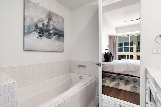 bathroom with a relaxing tiled tub and vanity