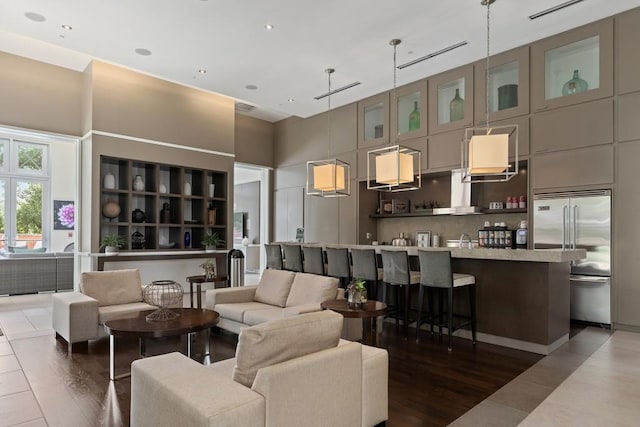 living room with a towering ceiling, dark hardwood / wood-style floors, and sink