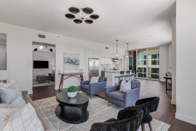 living room featuring a wall of windows, dark hardwood / wood-style floors, and a notable chandelier