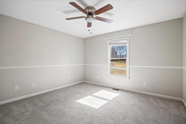 carpeted empty room featuring visible vents, baseboards, a textured ceiling, and ceiling fan