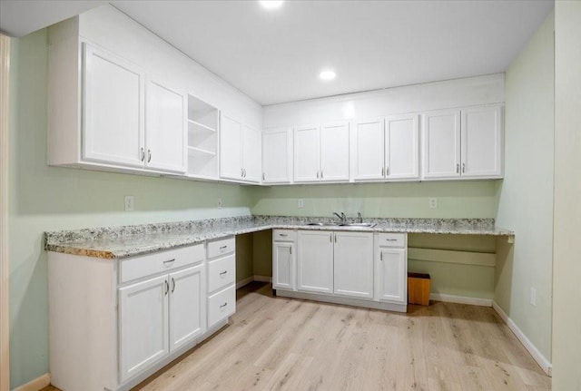 laundry room featuring recessed lighting, light wood-style flooring, baseboards, and a sink