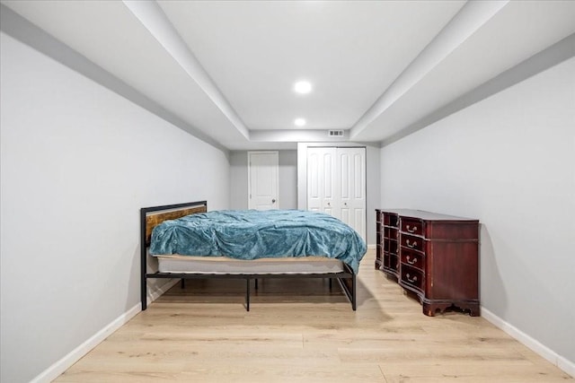 bedroom featuring light wood finished floors, visible vents, recessed lighting, and baseboards