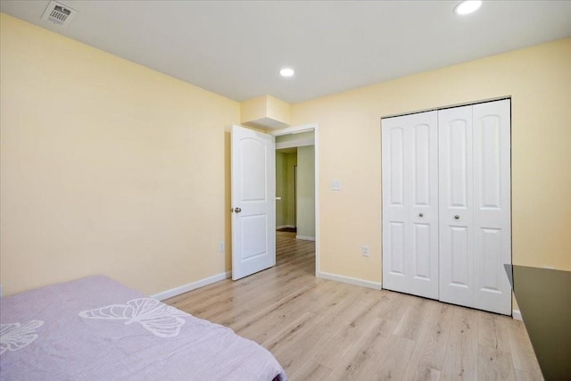 bedroom with visible vents, recessed lighting, a closet, light wood finished floors, and baseboards