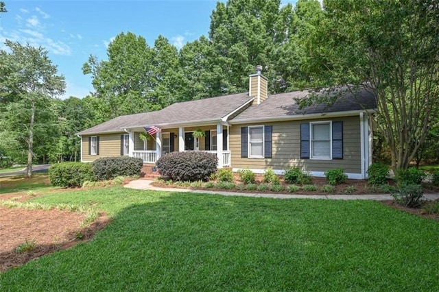 ranch-style home with a chimney, covered porch, and a front yard