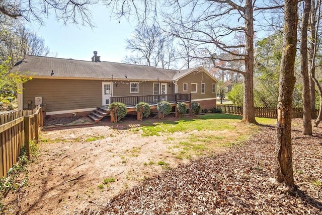 back of house with a fenced backyard, a chimney, and a deck