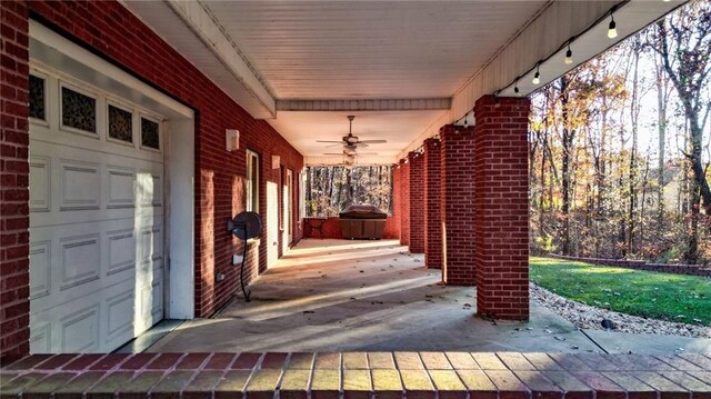 view of patio / terrace featuring a garage and ceiling fan