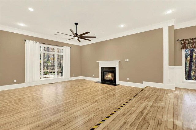 unfurnished living room featuring ceiling fan, light hardwood / wood-style floors, and ornamental molding