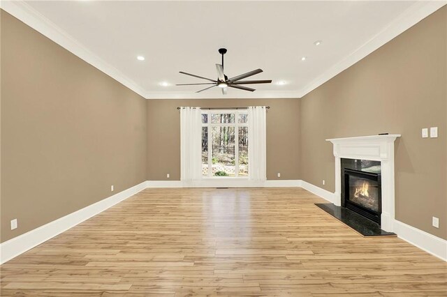 unfurnished living room with light hardwood / wood-style floors, ceiling fan, crown molding, and a premium fireplace