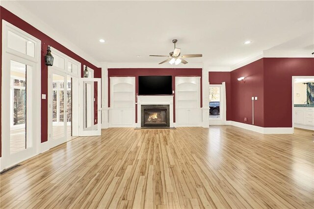 unfurnished living room featuring ceiling fan, a healthy amount of sunlight, and light hardwood / wood-style floors