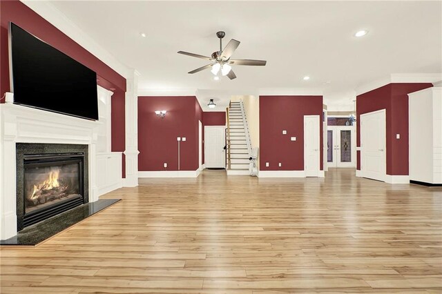 unfurnished living room with ceiling fan, light hardwood / wood-style floors, and a premium fireplace