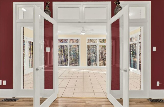 entryway with ceiling fan, a healthy amount of sunlight, light hardwood / wood-style floors, and french doors