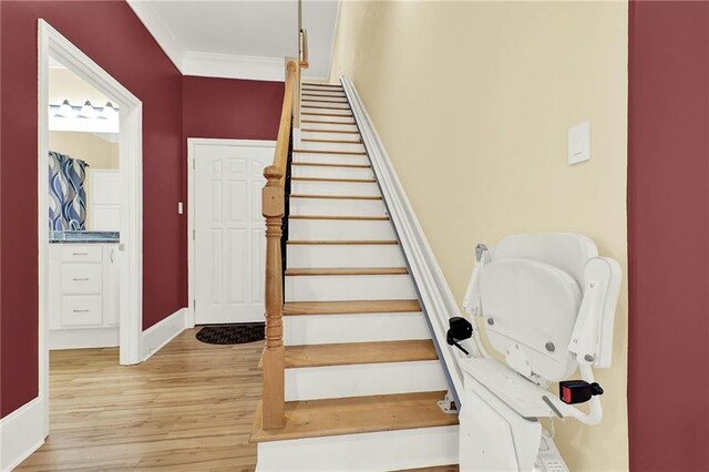 staircase with crown molding and hardwood / wood-style floors