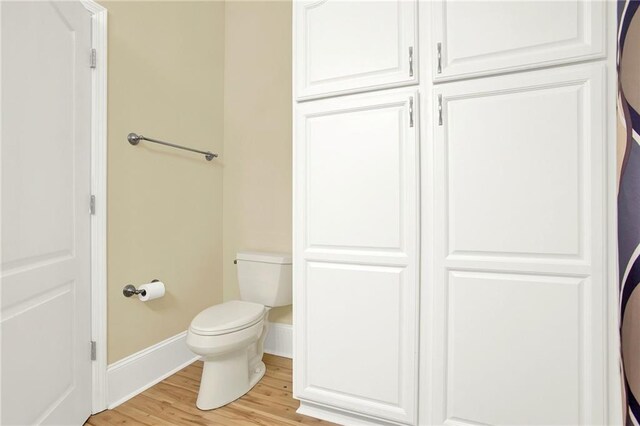 bathroom featuring wood-type flooring and toilet