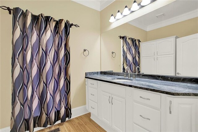 bathroom with crown molding, vanity, and wood-type flooring