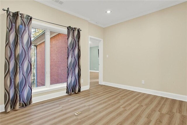 spare room with crown molding and light hardwood / wood-style floors