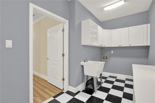 washroom featuring cabinets, washer hookup, light wood-type flooring, and crown molding