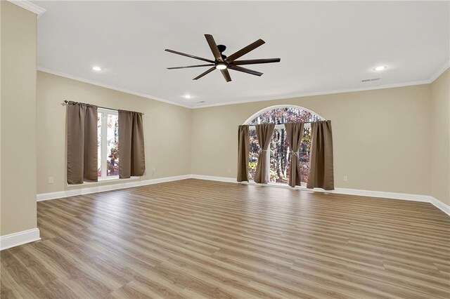 empty room with ceiling fan, ornamental molding, and light hardwood / wood-style flooring