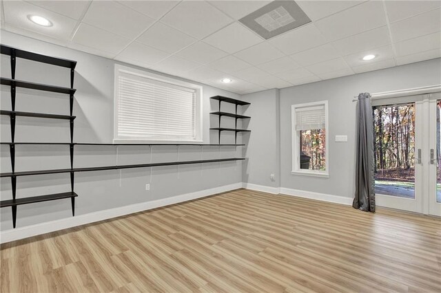 empty room with a paneled ceiling and light hardwood / wood-style floors