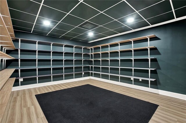 miscellaneous room with a paneled ceiling and hardwood / wood-style flooring