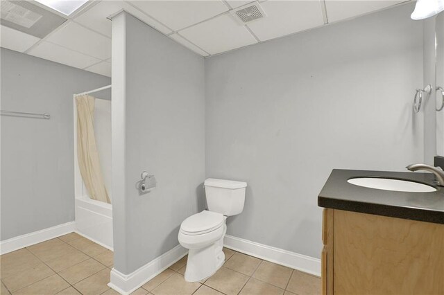 full bathroom featuring toilet, a paneled ceiling, tile patterned floors, and shower / bath combo with shower curtain