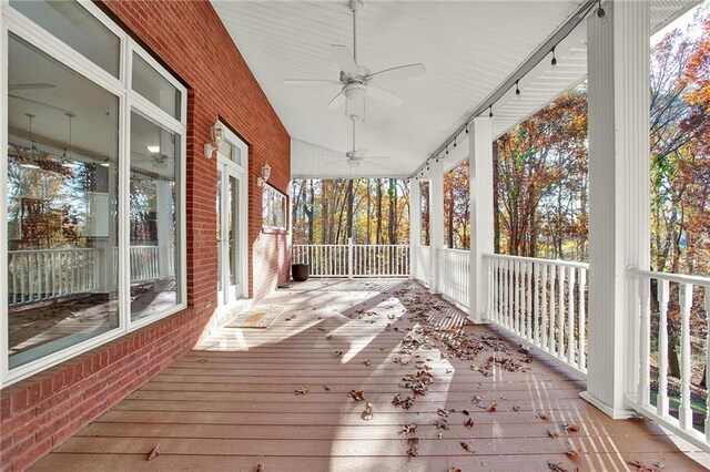 unfurnished sunroom featuring ceiling fan and a wealth of natural light