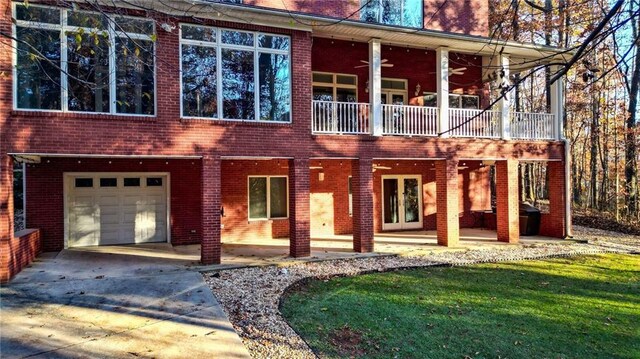 view of front of property with ceiling fan, a garage, and a front lawn