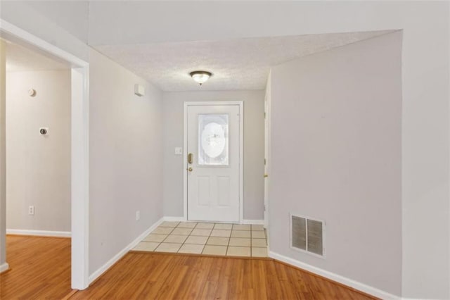 foyer with hardwood / wood-style flooring and a textured ceiling