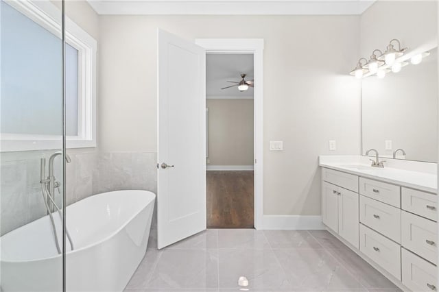 full bathroom with vanity, baseboards, and a freestanding bath