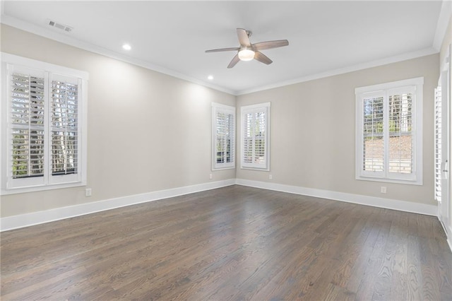 spare room with dark wood finished floors, baseboards, visible vents, and ornamental molding