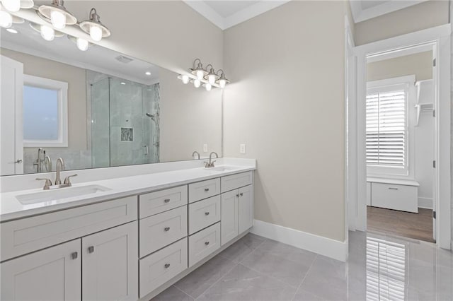 bathroom with crown molding, baseboards, a stall shower, and a sink