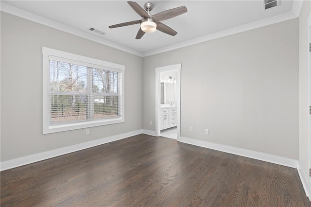 empty room featuring crown molding, baseboards, visible vents, and dark wood-style flooring