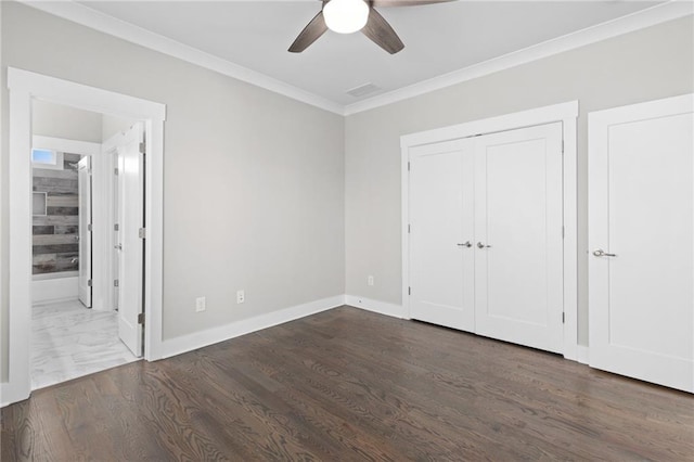 unfurnished bedroom featuring visible vents, connected bathroom, crown molding, baseboards, and wood finished floors