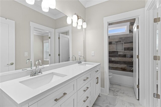 full bath with double vanity, marble finish floor, toilet, and a sink