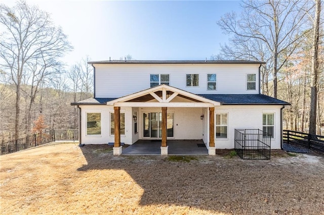 rear view of house featuring a patio and fence