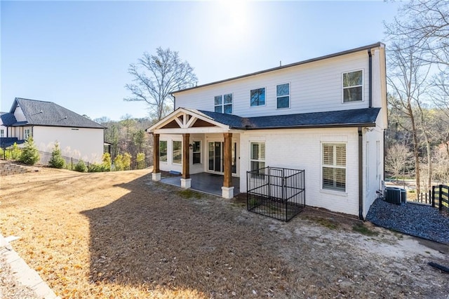 back of property featuring brick siding, central air condition unit, a patio, and fence