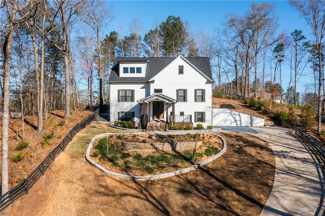 modern farmhouse style home with a gate, driveway, and stucco siding