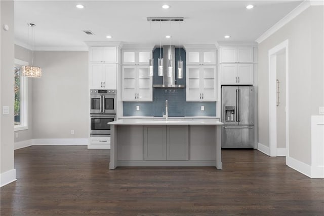 kitchen with a center island with sink, ornamental molding, stainless steel appliances, extractor fan, and light countertops