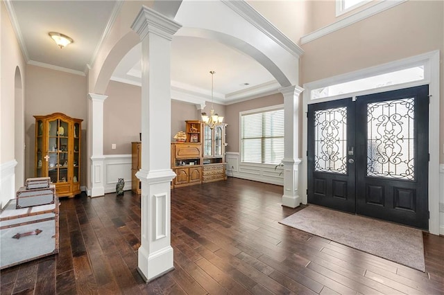 entrance foyer with decorative columns, crown molding, dark wood-type flooring, and french doors