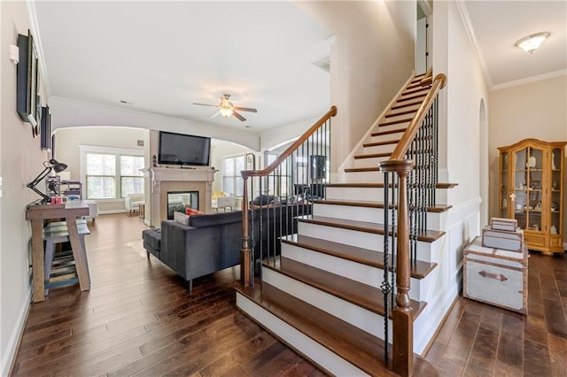 staircase with crown molding, hardwood / wood-style flooring, and ceiling fan