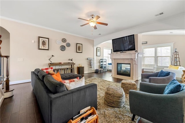 living room with crown molding, dark wood-type flooring, and ceiling fan