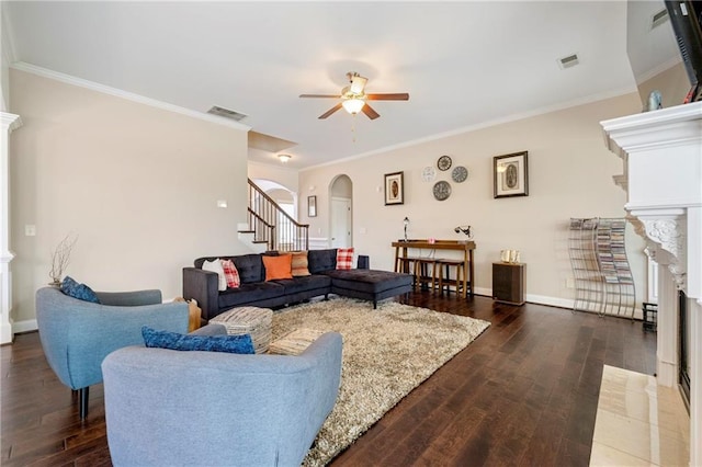 living room with crown molding, ceiling fan, a fireplace, and dark hardwood / wood-style flooring