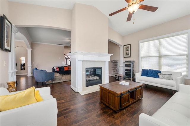 living room with lofted ceiling, dark hardwood / wood-style floors, ceiling fan, and ornate columns