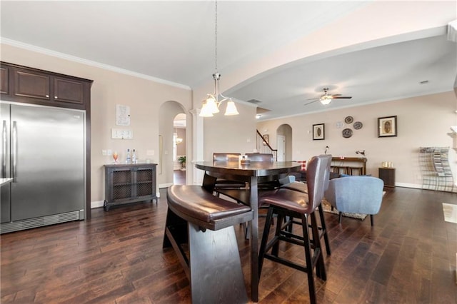 dining space with dark hardwood / wood-style flooring, ceiling fan with notable chandelier, and ornamental molding