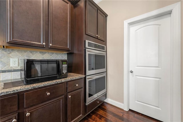 kitchen featuring double oven, dark hardwood / wood-style flooring, decorative backsplash, dark brown cabinetry, and light stone counters