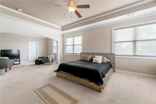 bedroom with ceiling fan, ornamental molding, carpet flooring, and a raised ceiling