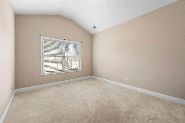 carpeted empty room with lofted ceiling