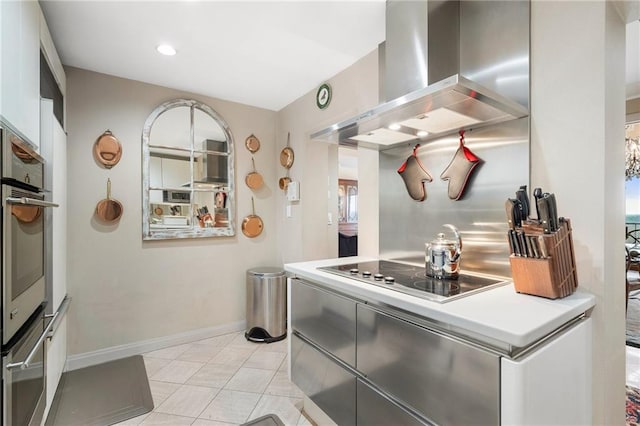 kitchen featuring light countertops, stainless steel oven, wall chimney range hood, baseboards, and black electric cooktop